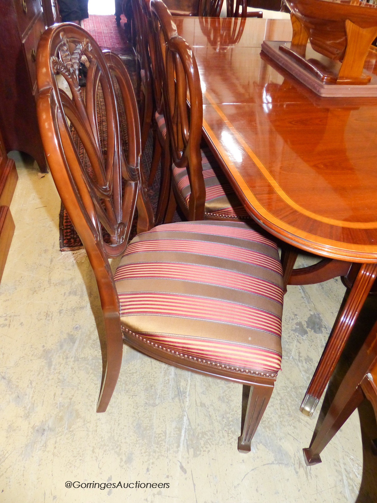 A reproduction Sheraton inlaid mahogany dining room suite, comprising twin pillar extending dining table, 240cm extended, one spare leaf, ten chairs, two with arms and sideboard. W-124, H-72cm.